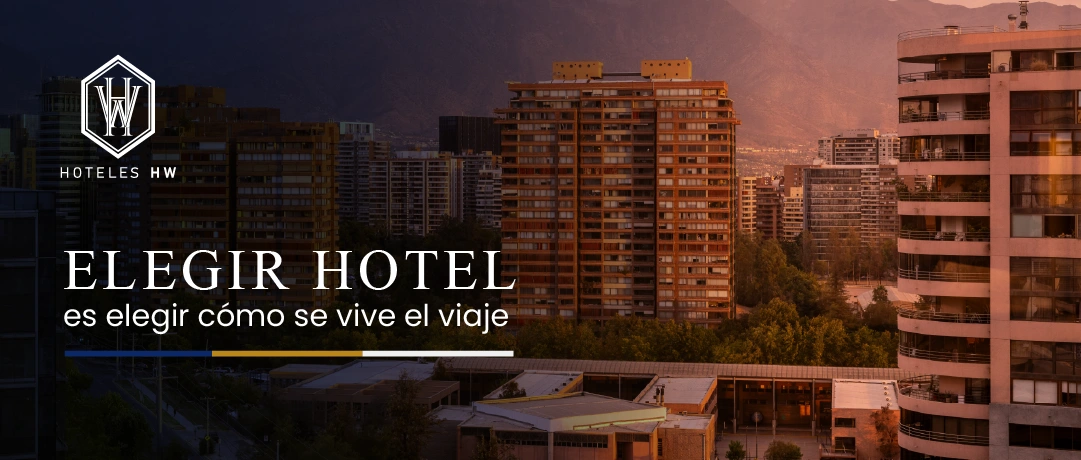 Vista panorámica de Santiago al atardecer con edificios y cordillera – Hoteles HW